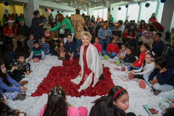 La autora Elizabeth Balaguer lee sentada en la alfombra rodeada de niños